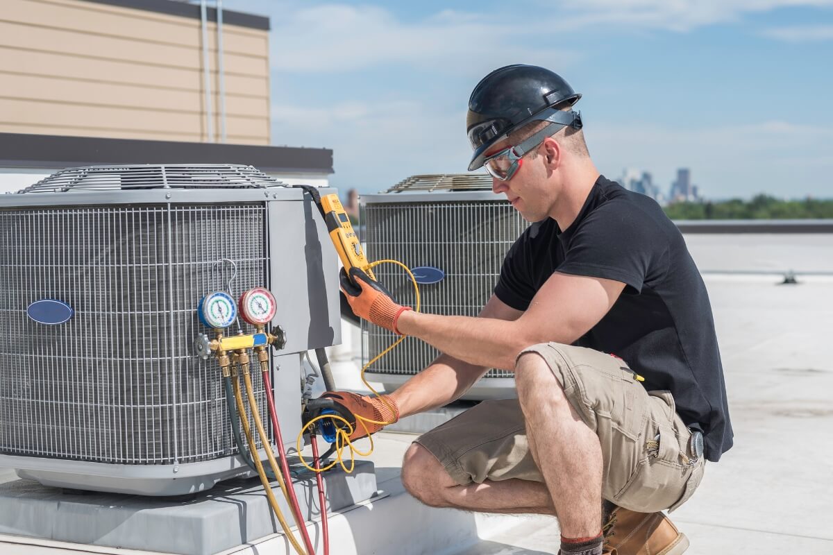 HVAC technician inspecting an condensing unit.